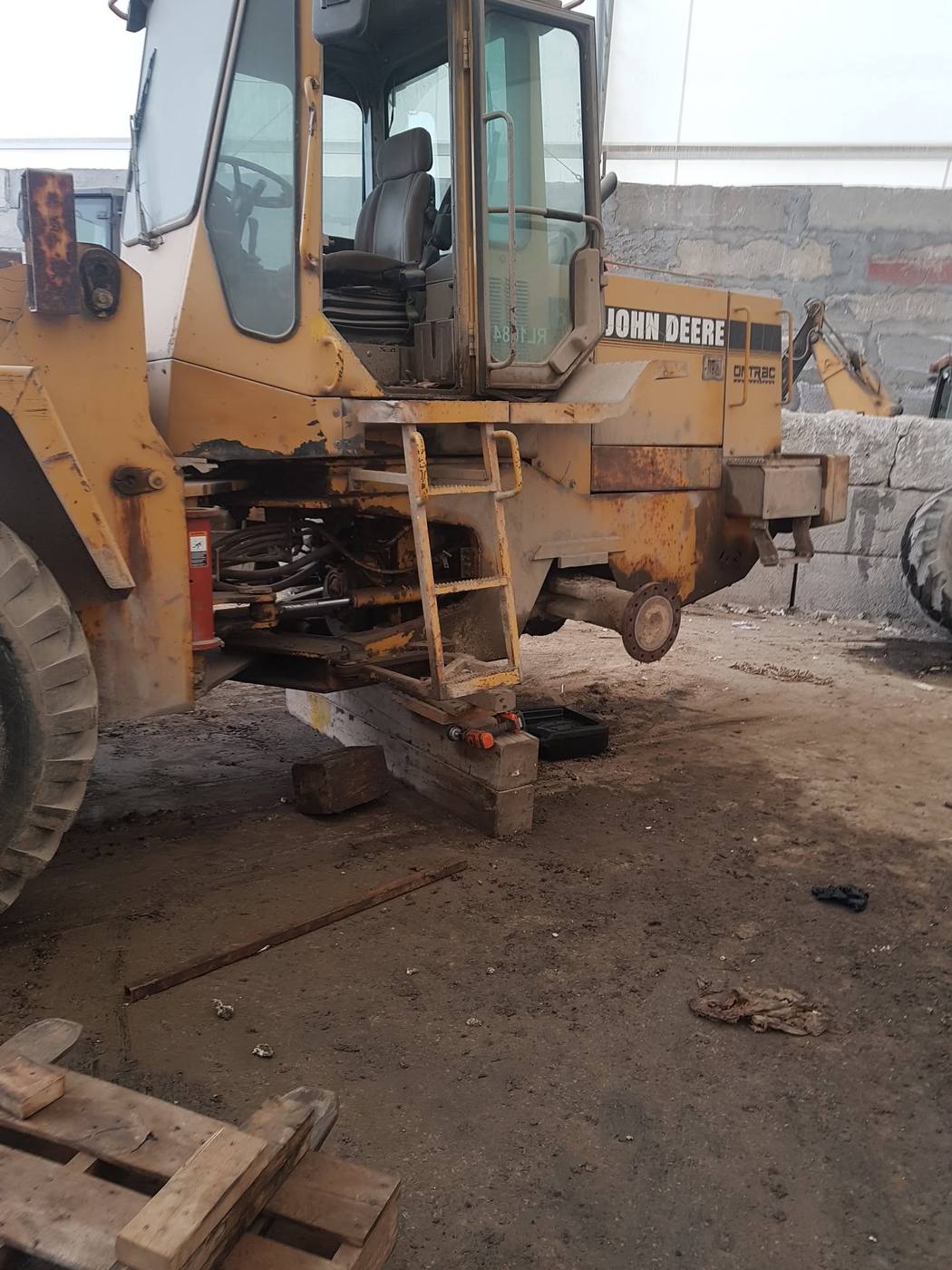 John Deere wheel loader raised on cribbing for axle and driveline repair